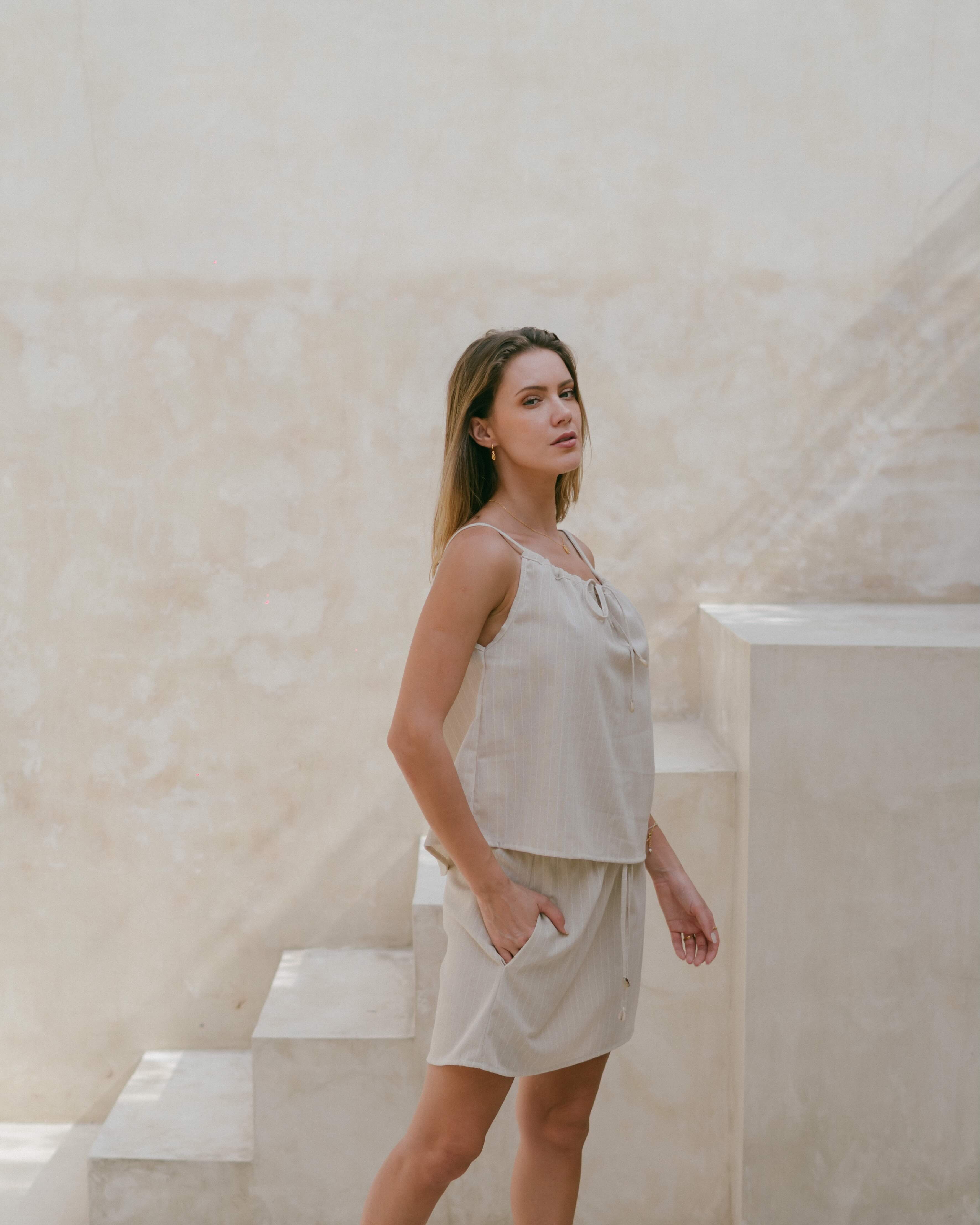 The perfect summer singlet with tie-up drawstring front, cowrie shells, and breezy fit.
