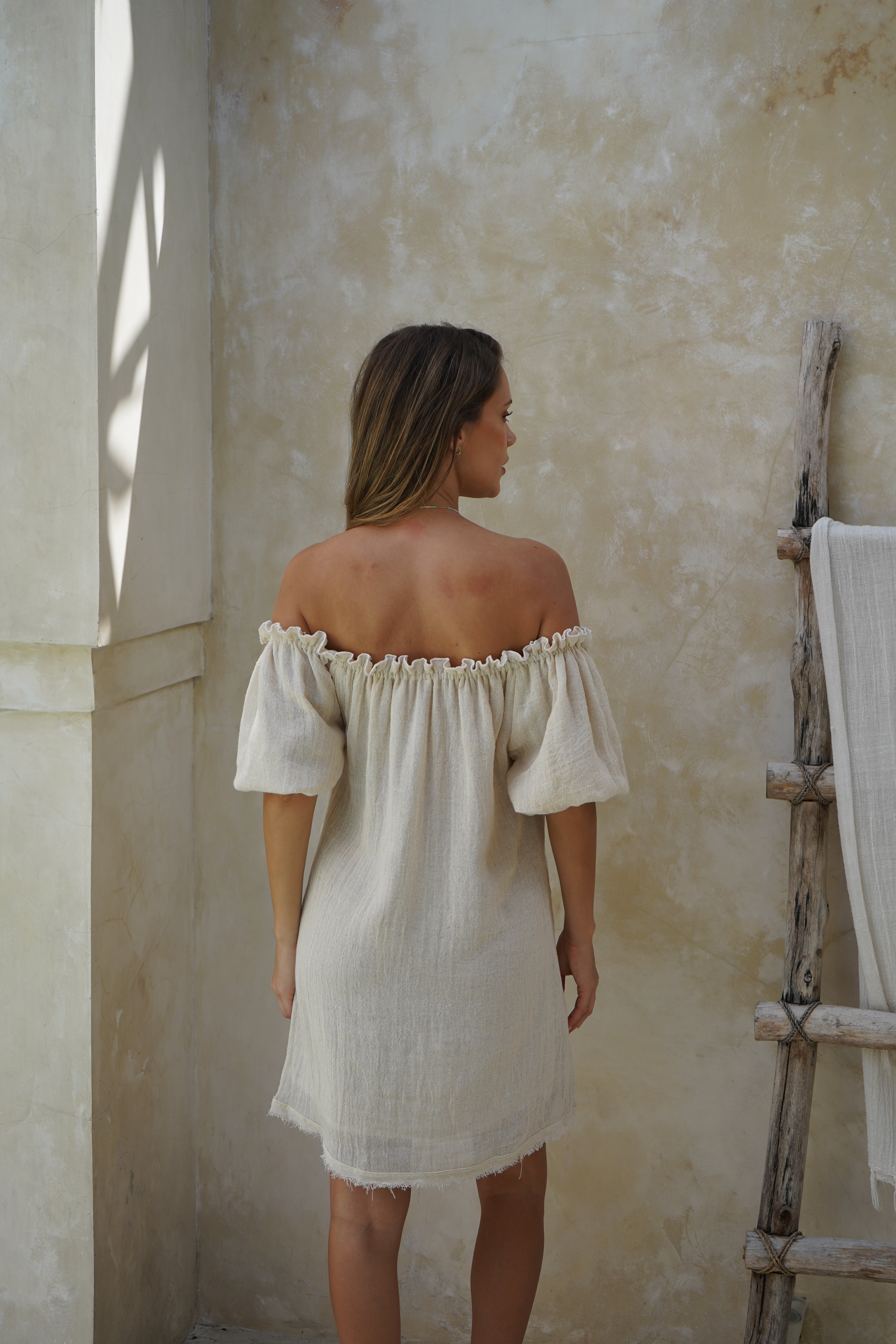 Lightweight ramie mini dress with puff sleeves, ruffle details, and a raw frayed finish. Double lined for comfort and ideal for beach-to-evening wear.