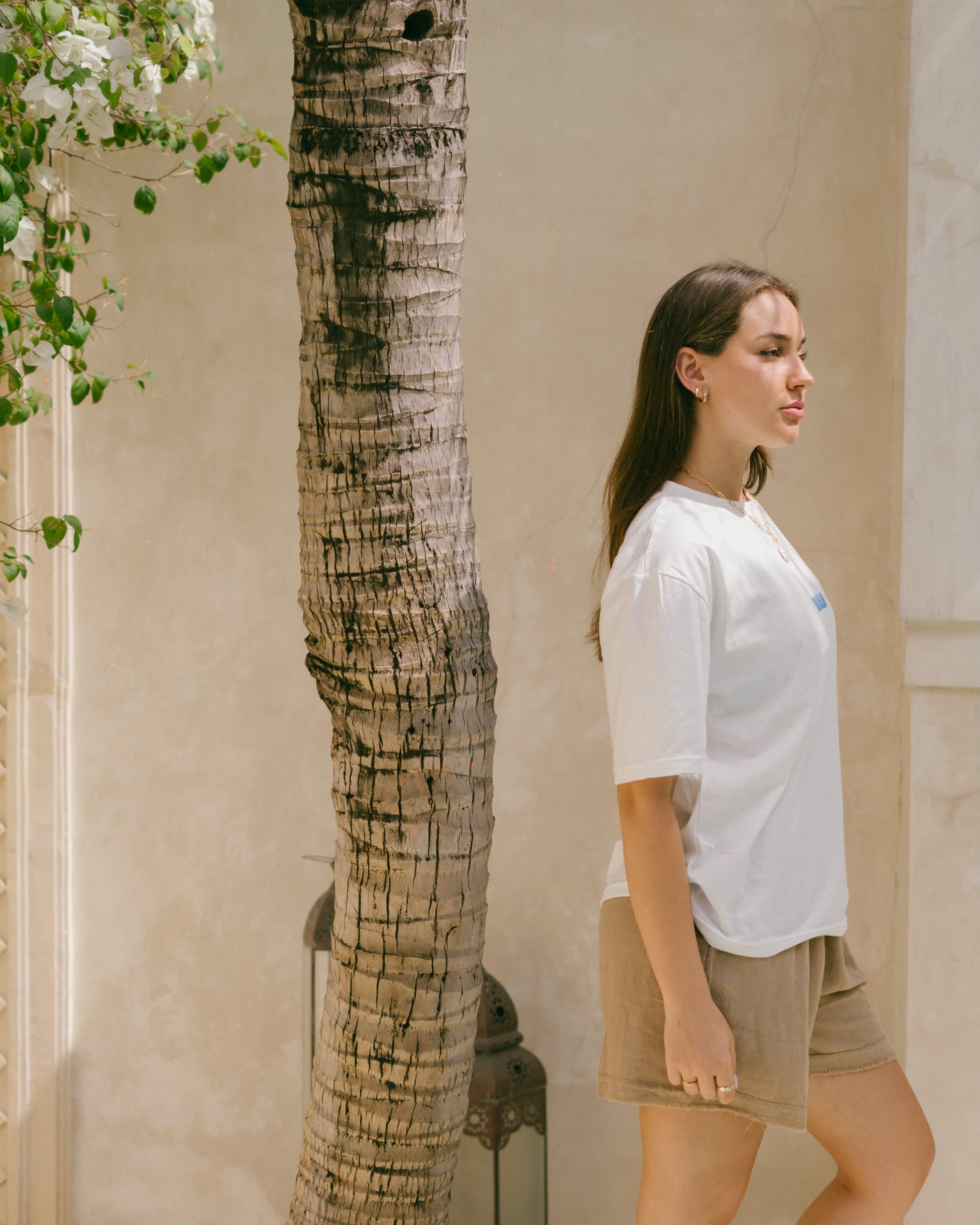 The ethical cotton tee offers breathable comfort, coastal-inspired design, and a mindful reminder to live with ease and intention.
