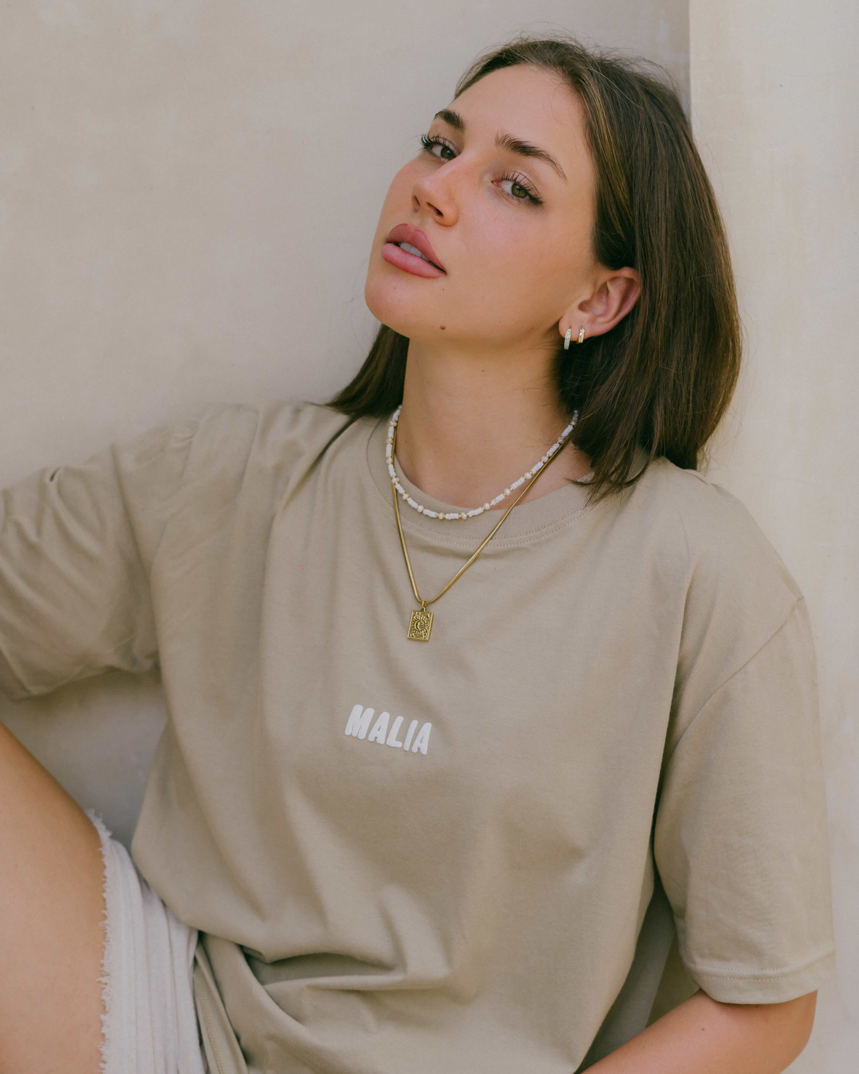 Shine day and night with Malia the label's water-resistant snake chain necklace, featuring a square pendant of a moon nestled inside the sun. Perfect for everyday wear, this celestial-inspired piece adds timeless style to any outfit.