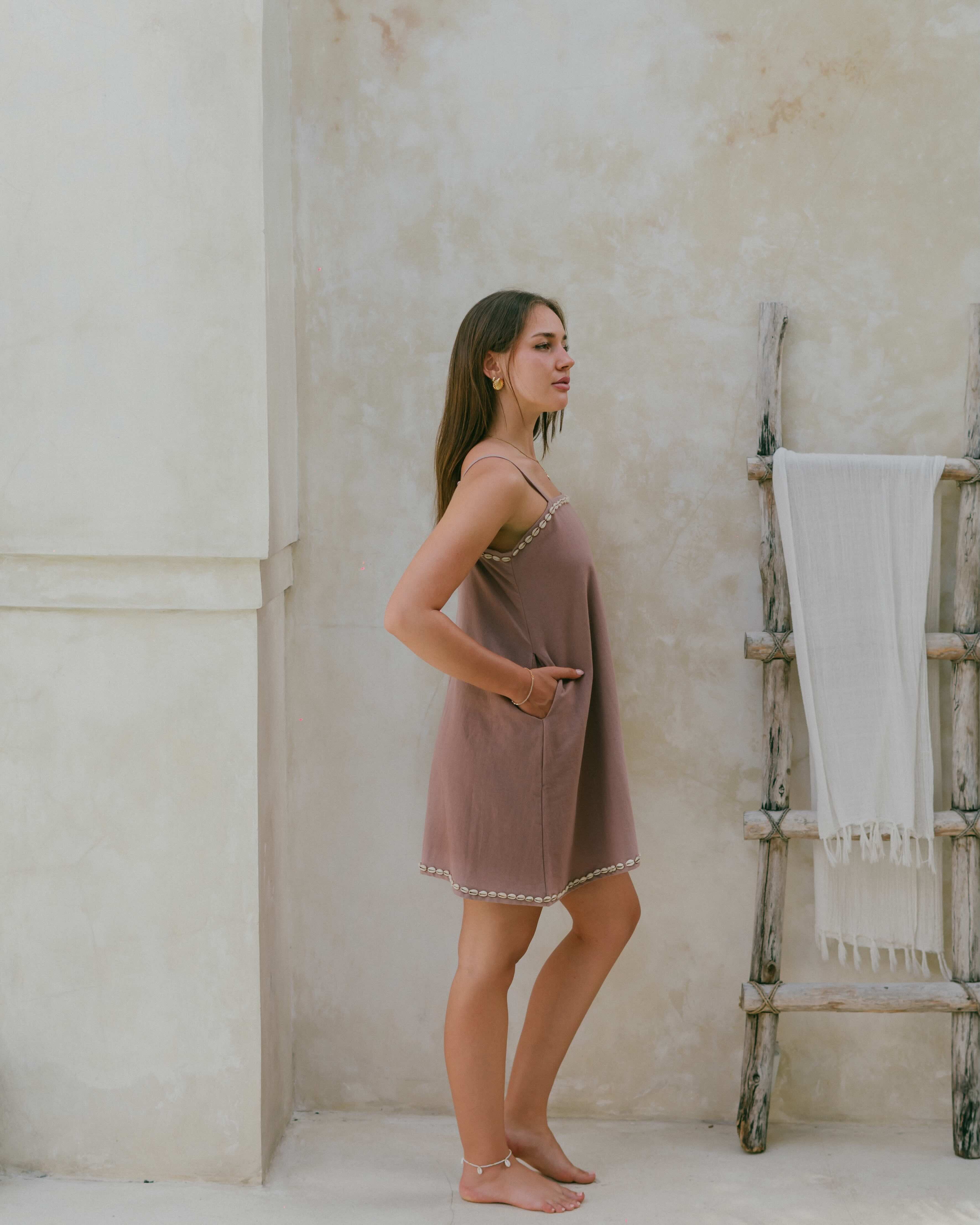 Designed for carefree summer days, the relaxed shift mini dress has cowrie shell details, a flowy fit, and a coastal-inspired charm.