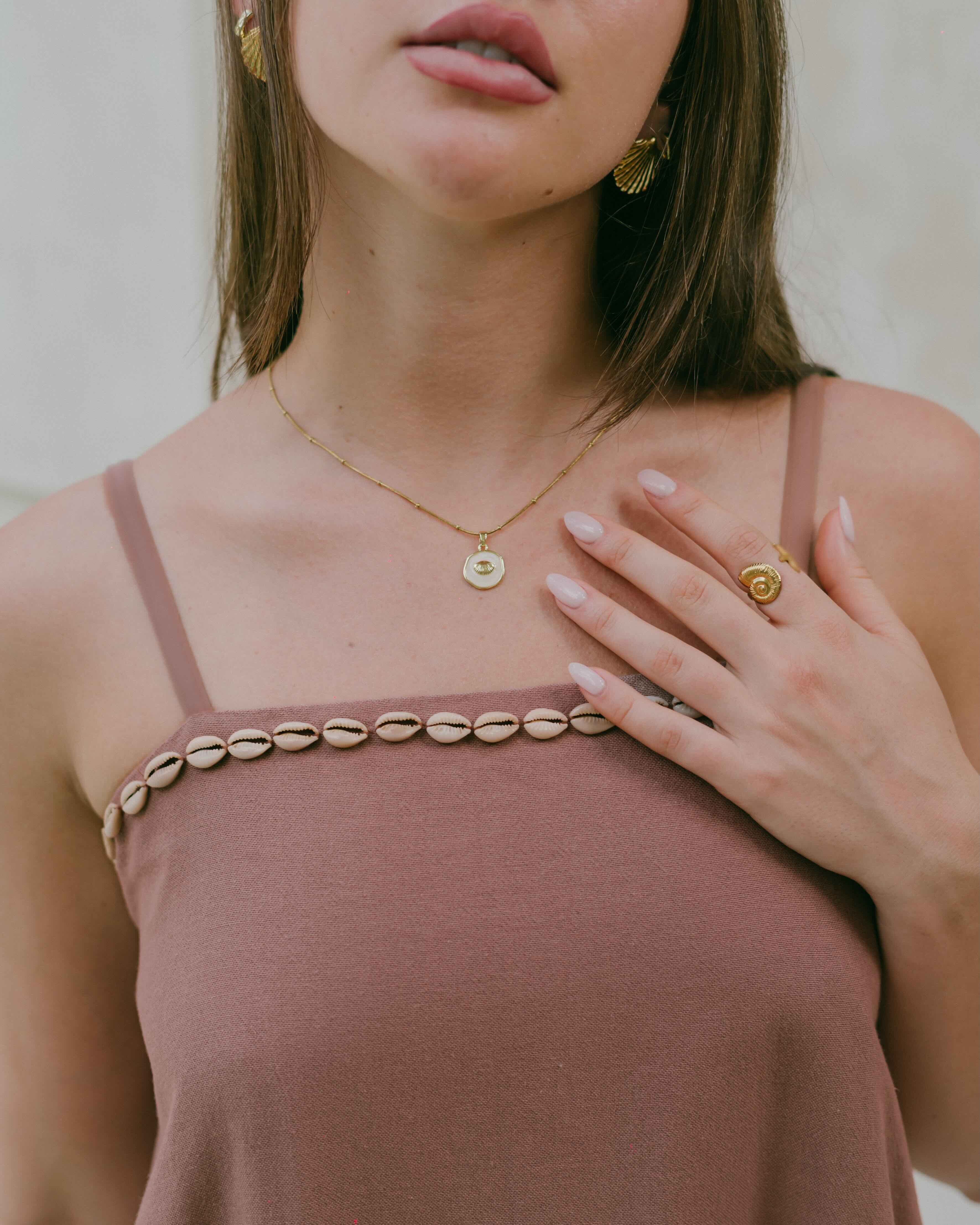 With cowrie shell hems and a flowy silhouette, this coastal mini dress is lightweight, relaxed, and perfect for every sun-drenched occasion.