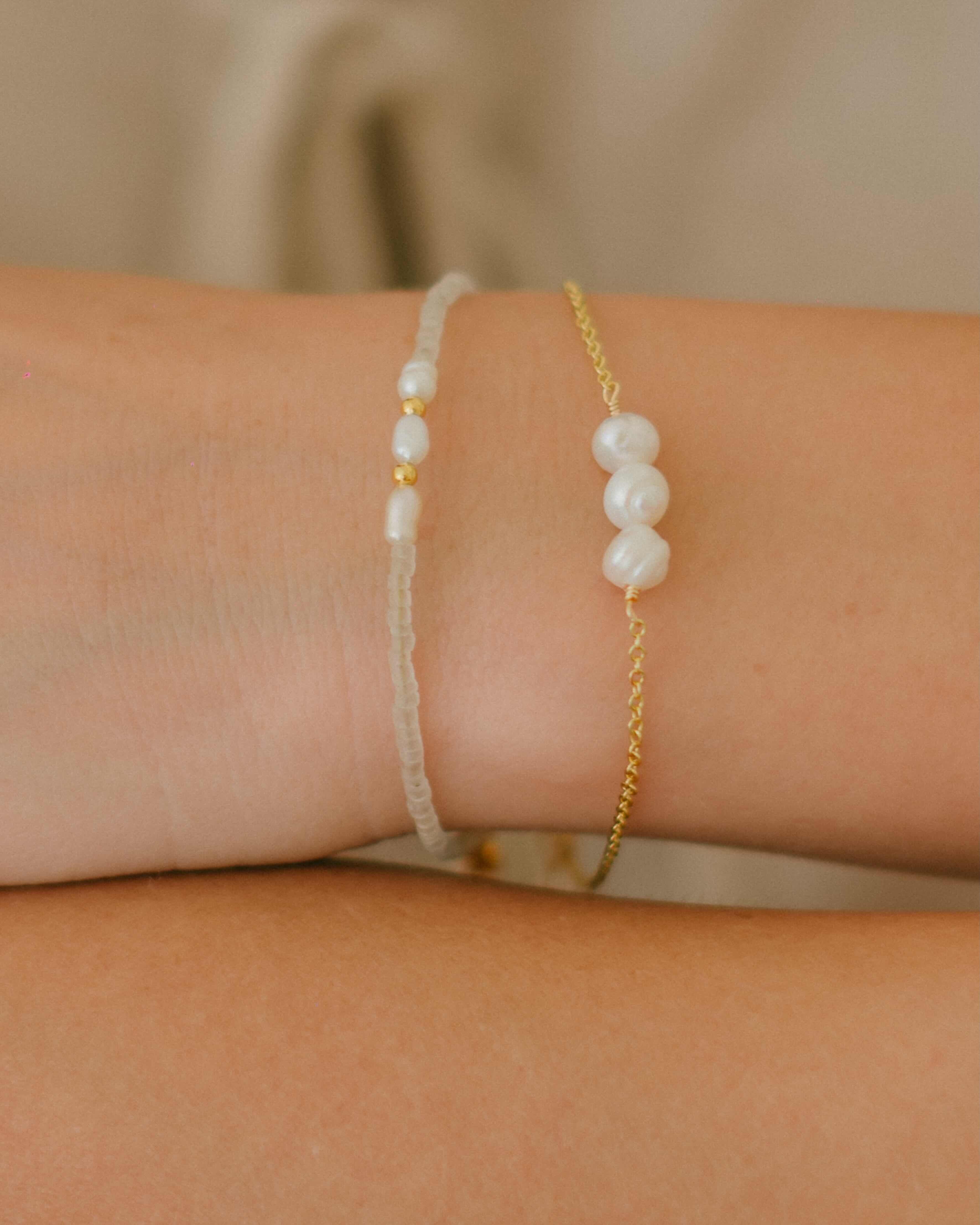 Shop the Marina Pearl Bracelet—a gold chain bracelet with three freshwater pearls in the centre and a pearl accent by the clasp. Elegant, timeless, and perfect for layering.