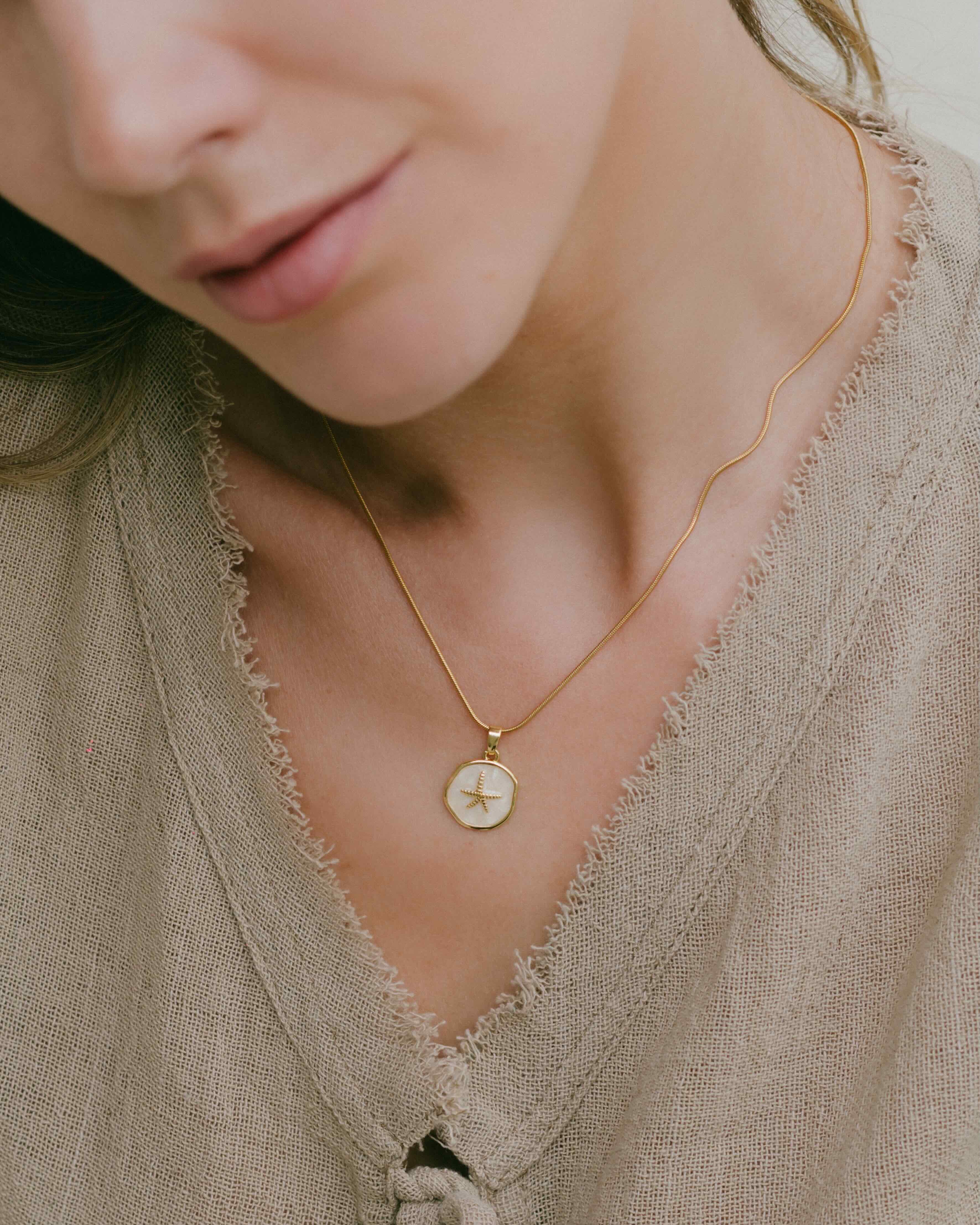 Elevate your jewellery collection with the Soraya Starfish Necklace, featuring a circle-detail gold chain and a starfish-accented shell pendant. Durable, waterproof, and perfect for beach lovers seeking timeless style.