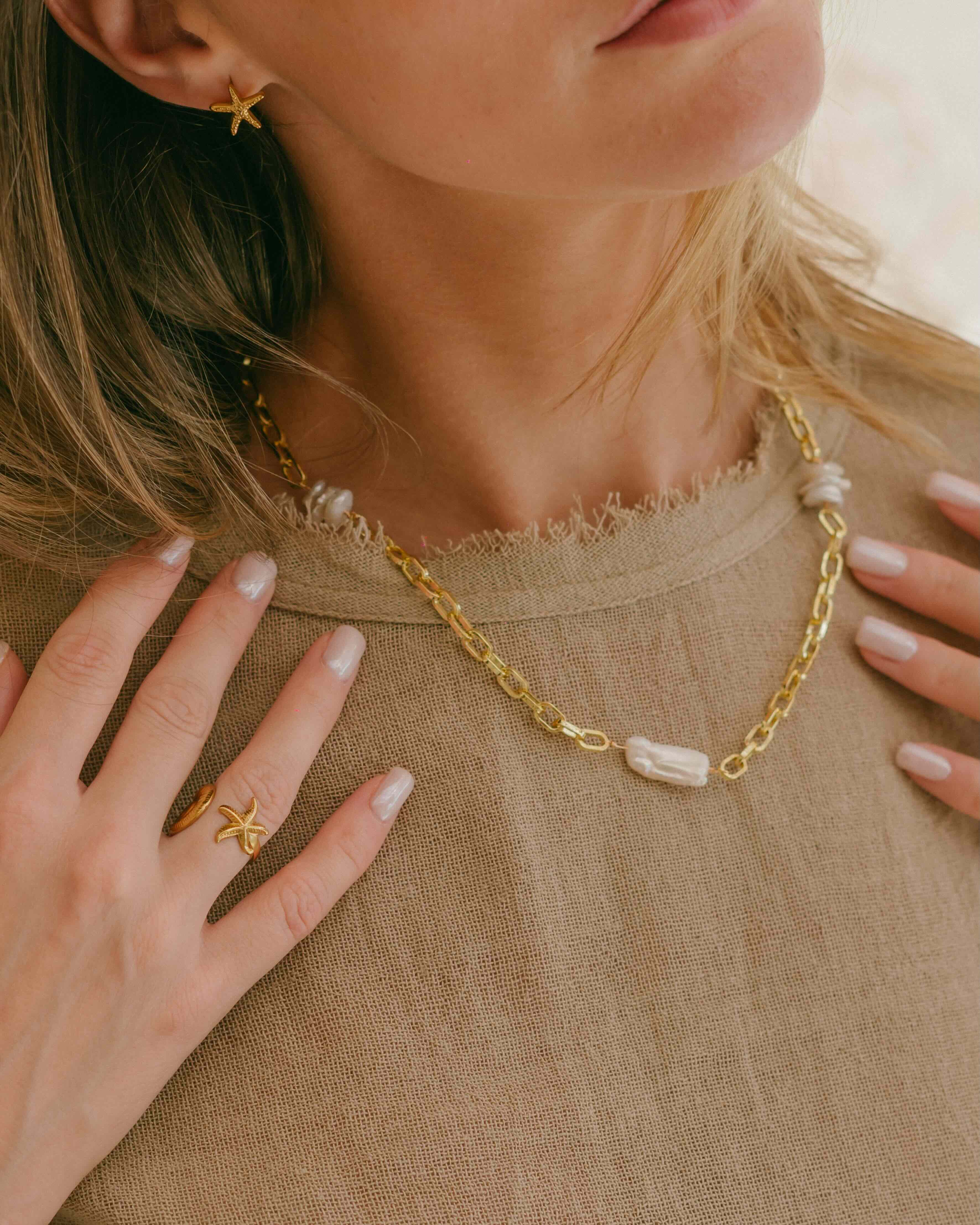 Shop the Pearl Cascade Necklace—an 18k gold plated chunky chain adorned with three long freshwater pearls and a secure hook and pole clasp. Ideal for statement layering or standalone elegance.