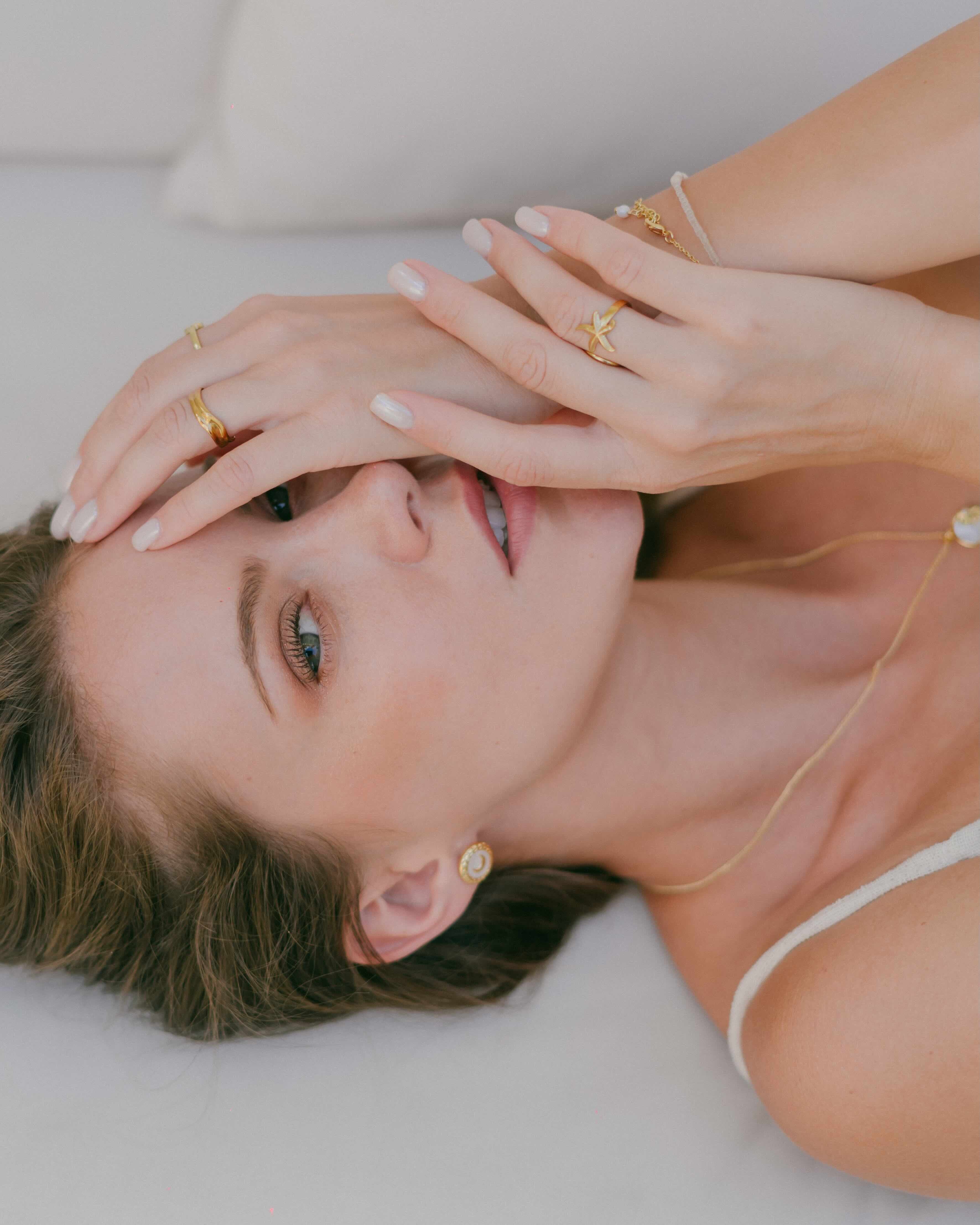Discover the perfect blend of moonlight and ocean vibes with Elara Stud Earrings. Gold-tone studs with shell-inspired design and textured borders add subtle elegance to your jewellery collection.