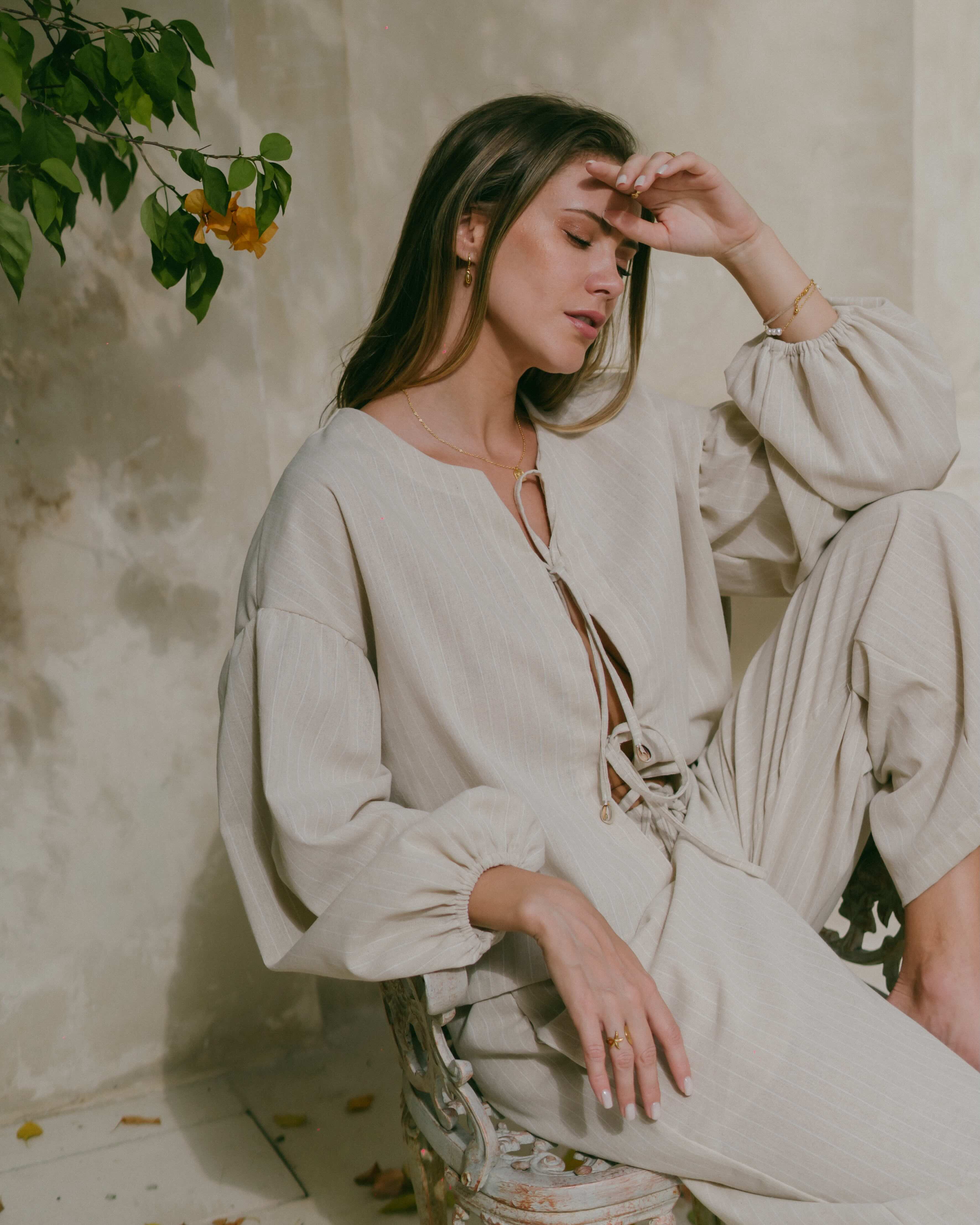 Romantic boho-inspired Amalfi top featuring flowy bishop sleeves, cowrie shell ties, and a relaxed beachy fit.
