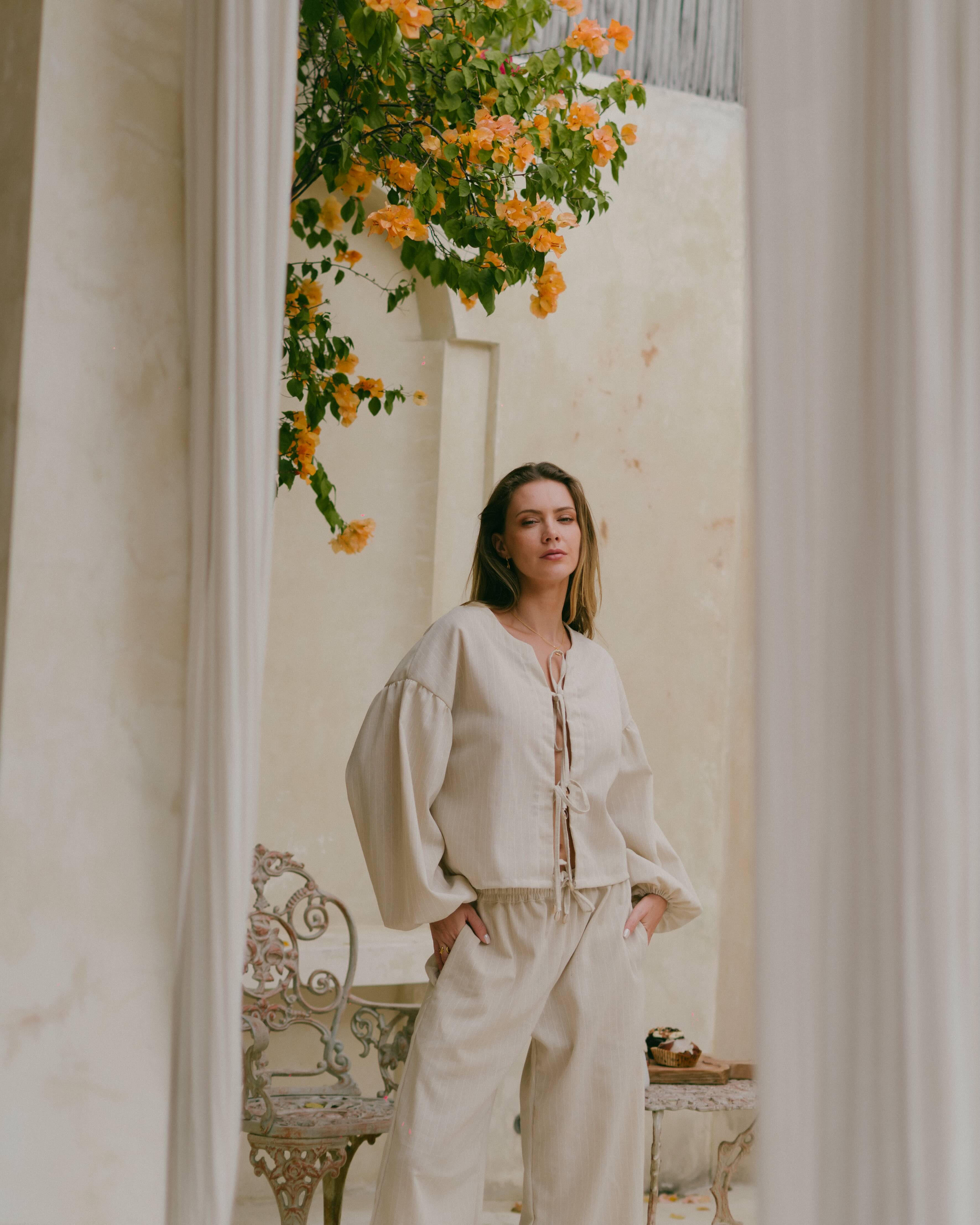 The Amalfi Top – a Euro summer–inspired long sleeve tie-up blouse with bishop sleeves and cowrie shell details.