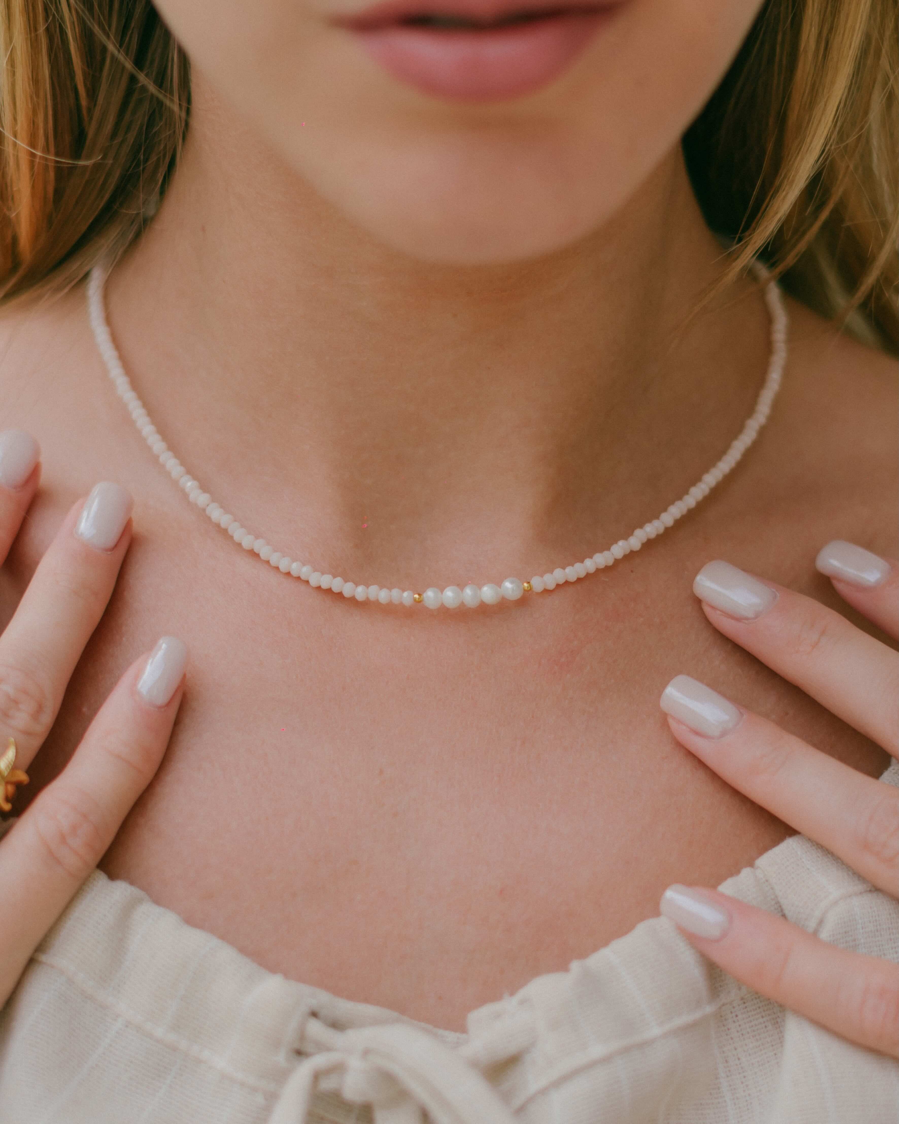 Shop the Blush Pearl Necklace—baby pink crystal beads and freshwater pearls on a gold plated chain. Perfect for layering or adding a soft, elegant touch to any look.