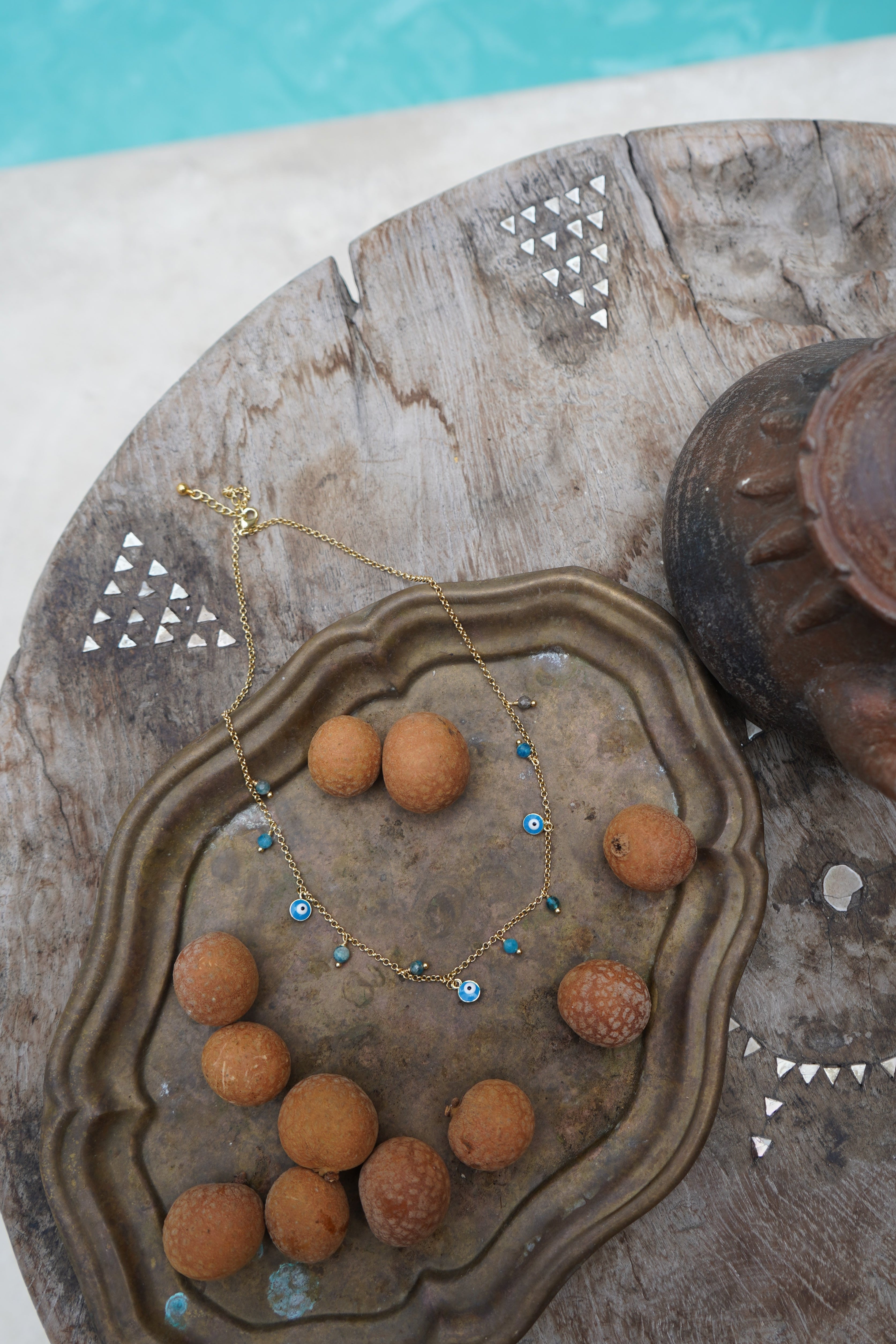 Apatite stone and evil eye detailed gold necklace by Malia the label. 