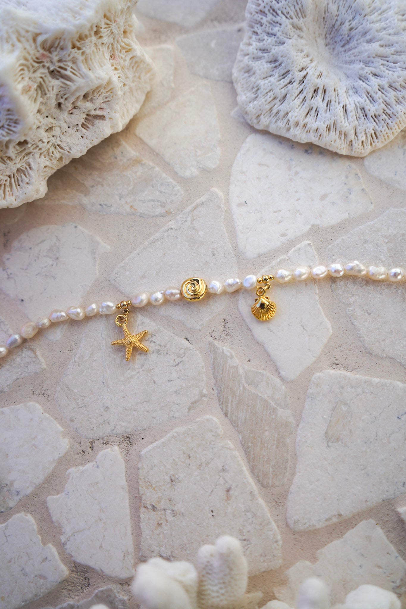 Elevate your style with the Golden Days Pearl Bracelet, featuring lustrous pearls and three gold charms inspired by the sea. Perfect for everyday wear or seaside escapes.