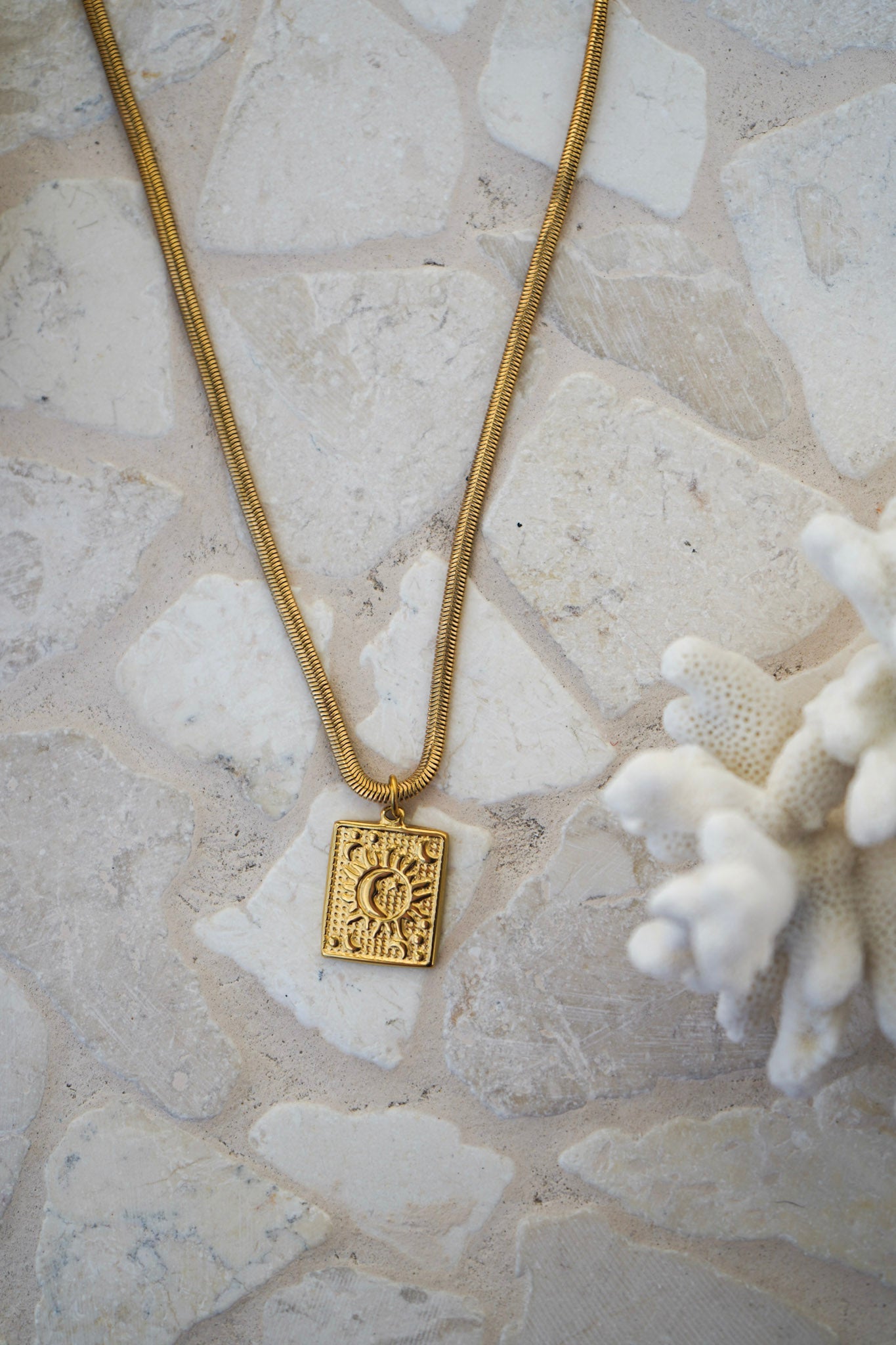The Soluna Pendant Necklace blends sun and moon symbolism in a sleek, water-resistant design. A square pendant on a snake chain makes it the perfect gold necklace for layering or wearing solo, from the beach to the city.
