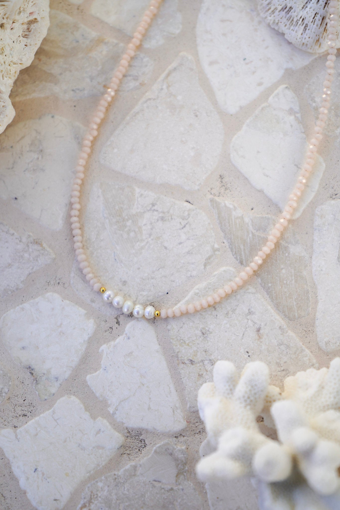 Elevate your style with the Blush Pearl Necklace, featuring delicate pink crystals and three freshwater pearls on a gold chain. A feminine, versatile accessory for everyday wear.