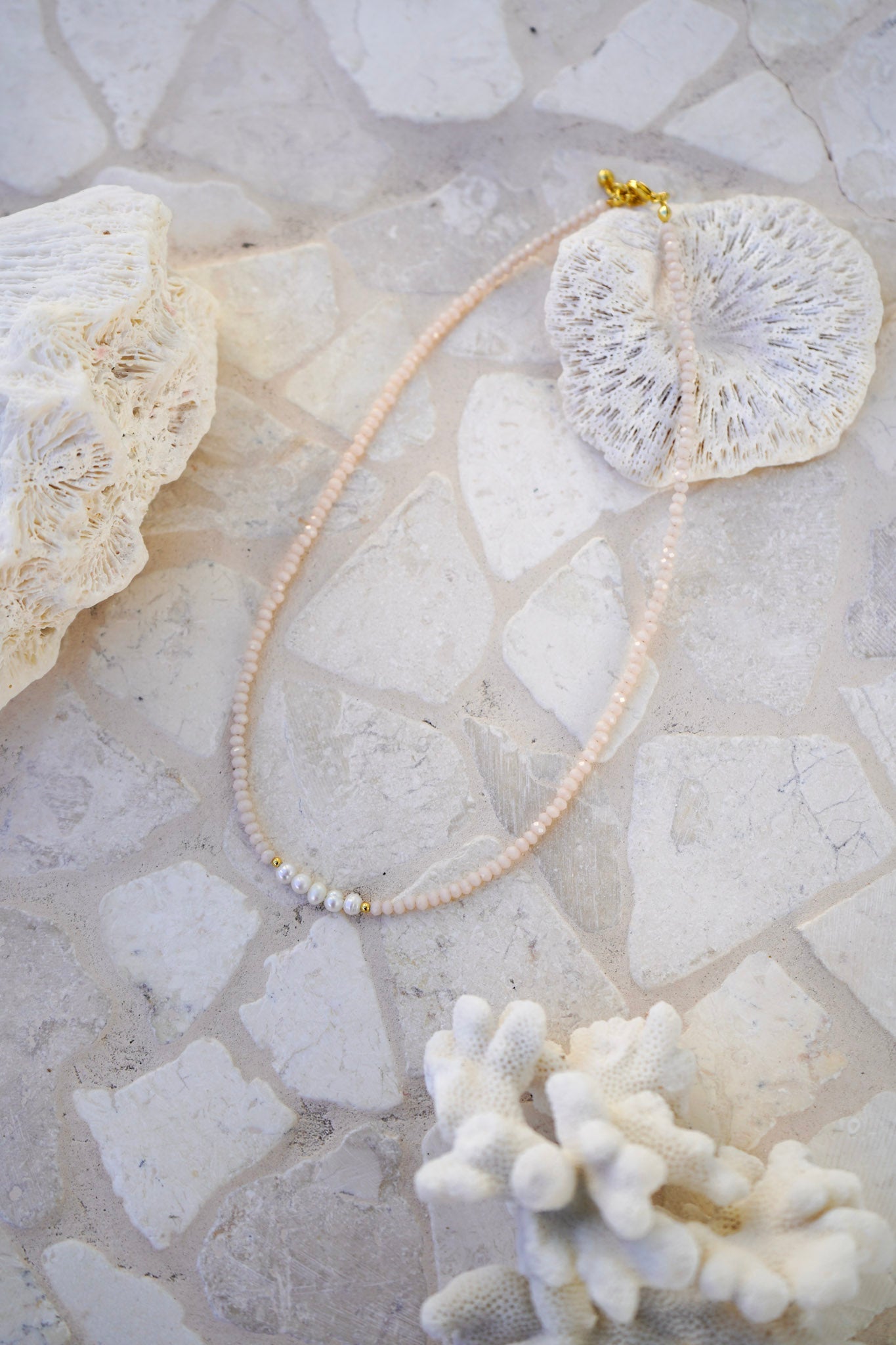 Discover timeless elegance with the Blush Pearl Necklace. Baby pink crystals and freshwater pearls combined on a gold plated chain make this necklace ideal for layering or statement wear.