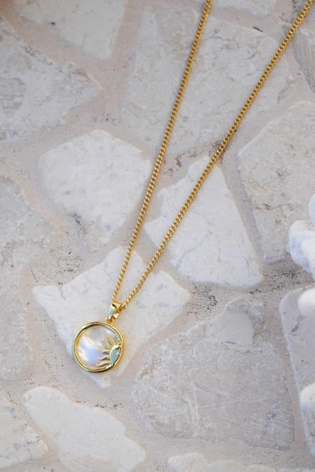 Discover celestial charm with the Sunstone Pearl Pendant Necklace, combining a gold sun-ray design and lustrous pearl on a delicate gold chain. Ideal for adding sunshine to your jewellery collection.