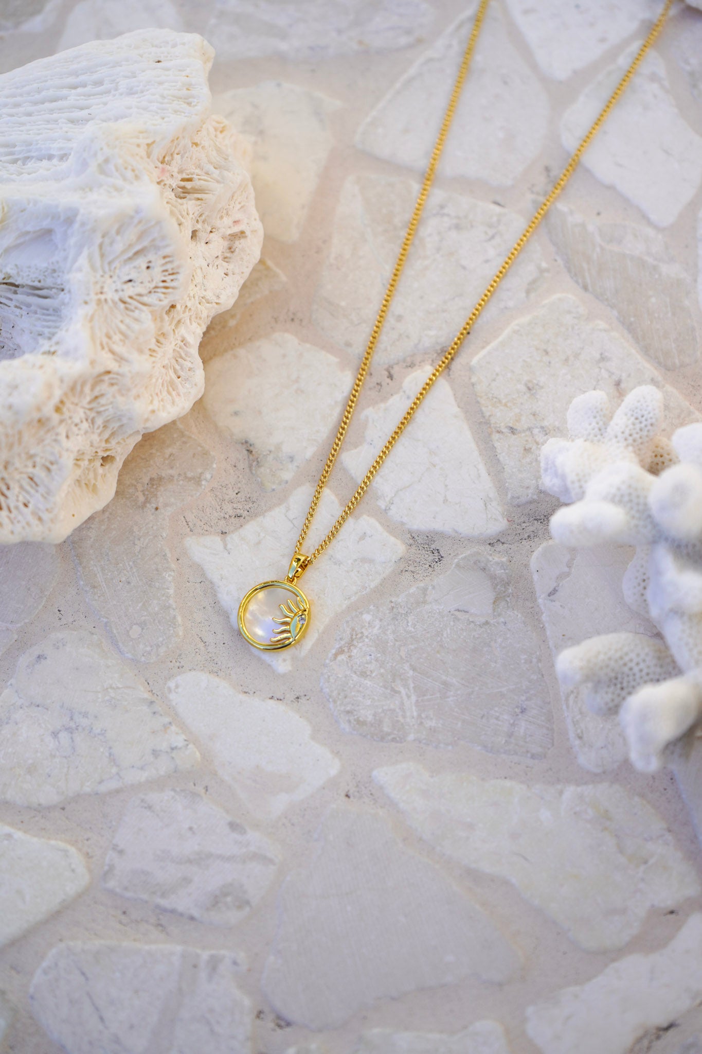 Add radiant elegance to your jewellery box with the Sunstone Pearl Pendant Necklace—an 18k gold chain with a sun-inspired gold outline and pearly pendant. Perfect for layering or solo wear.