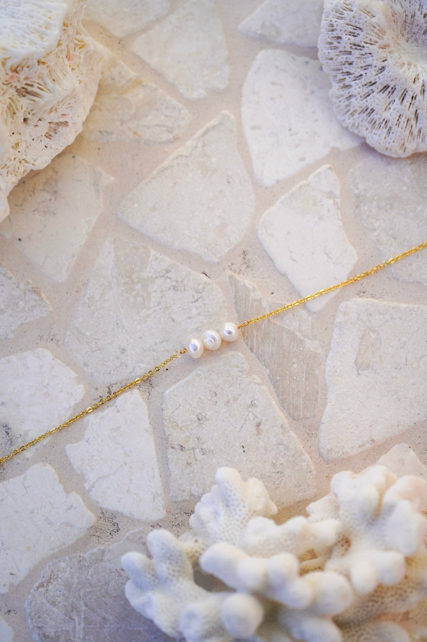 Elevate your jewellery collection with the Amara Pearl Bracelet, featuring three centre pearls and a clasp detail pearl on a gold chain. A versatile accessory for any occasion.