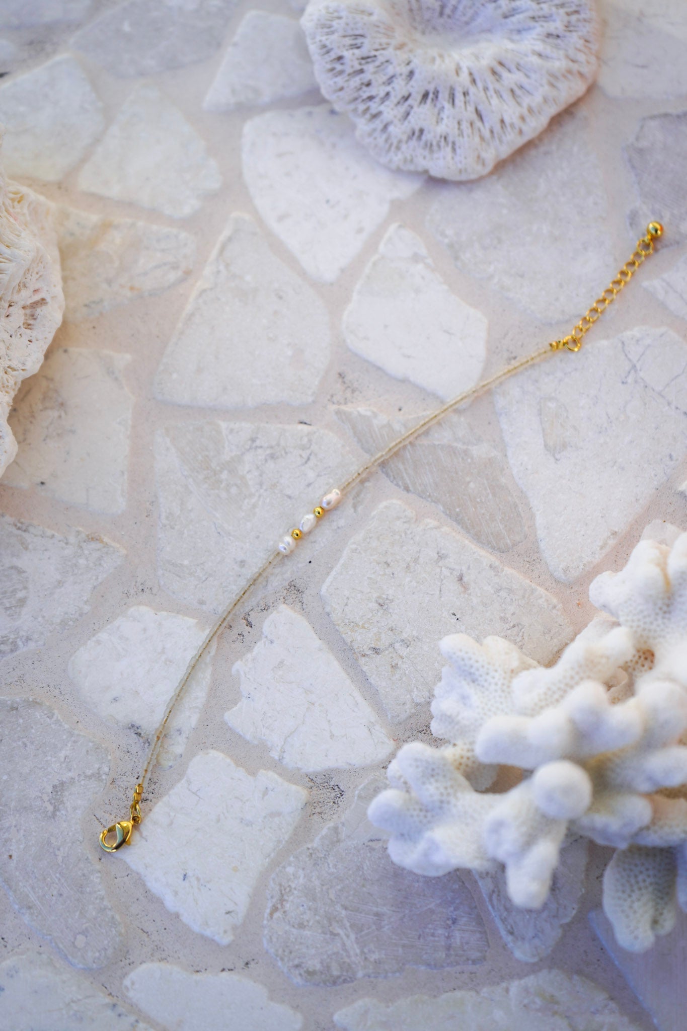 Discover the Shoreline Pearl Necklace—minimalist beige beads with three freshwater pearls. A versatile, beach-inspired necklace for everyday wear.