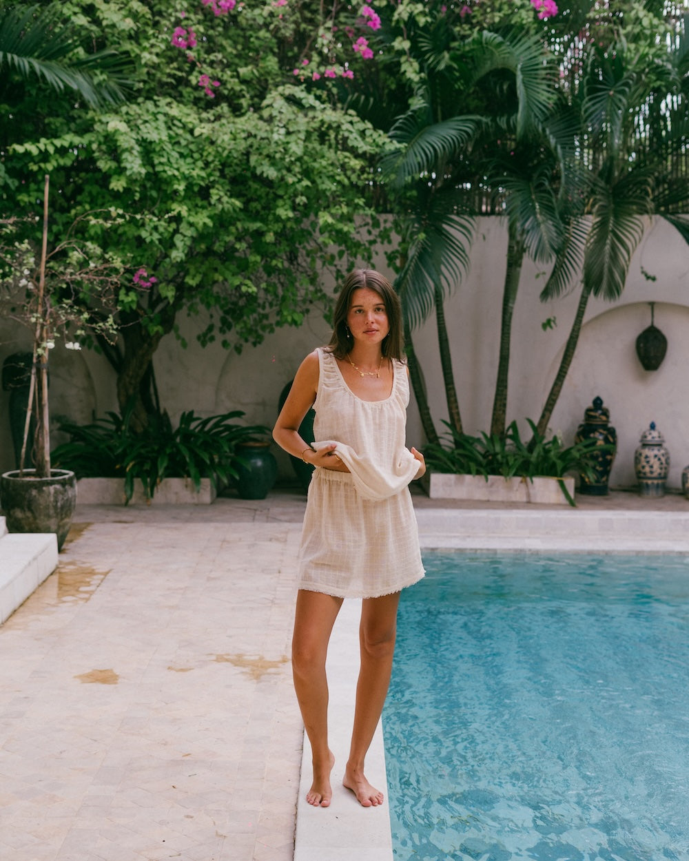 Sofia Singlet Top and Mini Skirt co-ord set — model standing barefoot poolside, full-length front view showing complete matching set in natural check ramie, timber door setting — slow fashion matching set Australia — Malia The Label La Dolce Vita