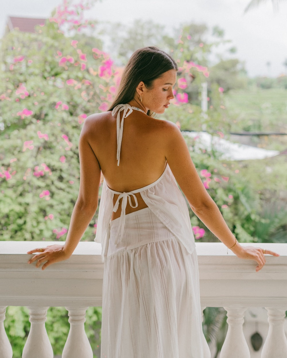Sole Mare Singlet Top and Mini Skirt on villa balcony — back view of gathered halter neckline tie up and maxi skirt co-ord in white handloomed cotton — slow fashion white cotton matching set — Malia The Label Australia