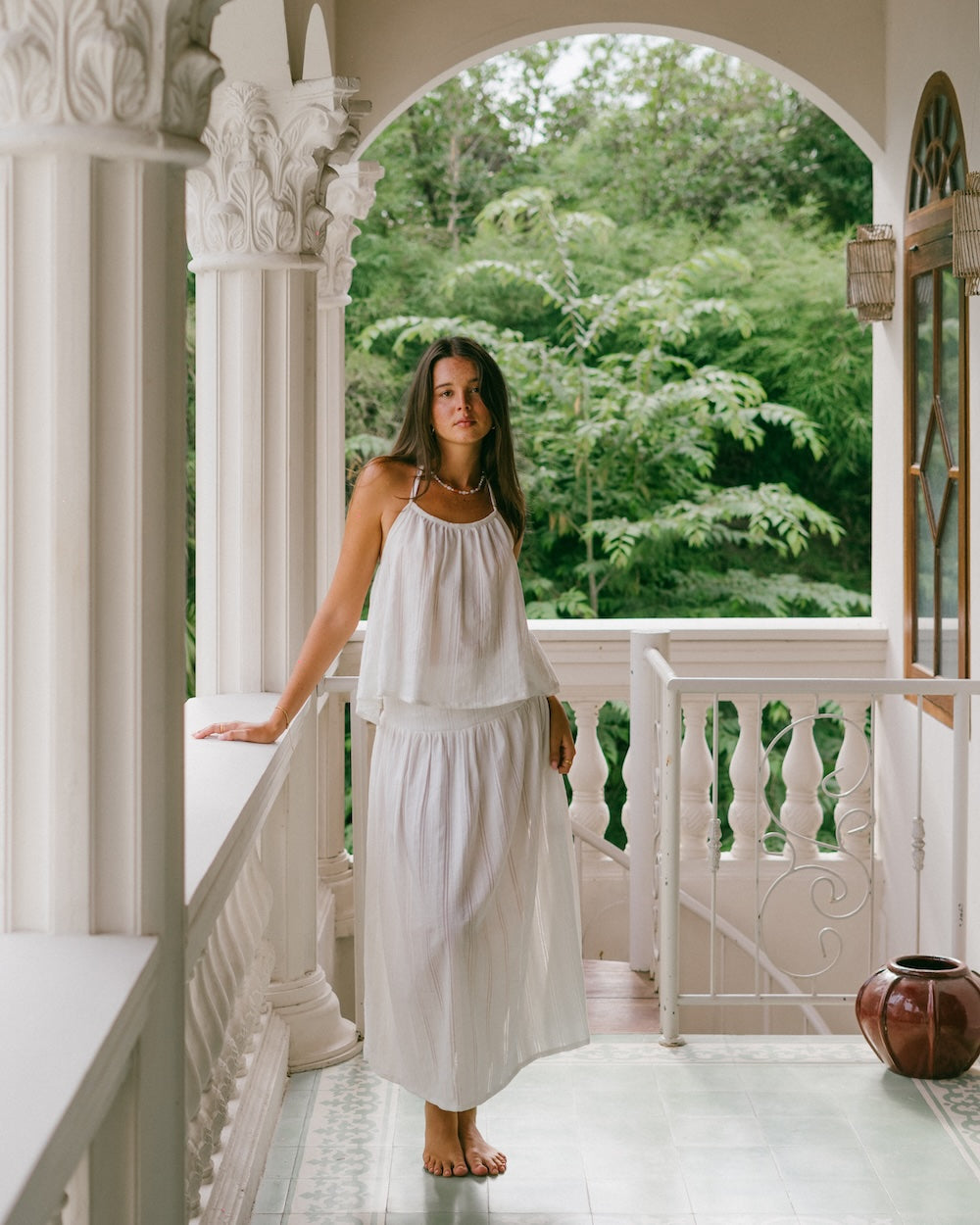 Sole Mare Singlet Top and Maxi Skirt full matching set — model standing on ornate white villa balcony, full-length front view showing gathered halter top and floor-length maxi skirt in handloomed white cotton — slow fashion white co-ord set — Malia The Label La Dolce Vita Australia