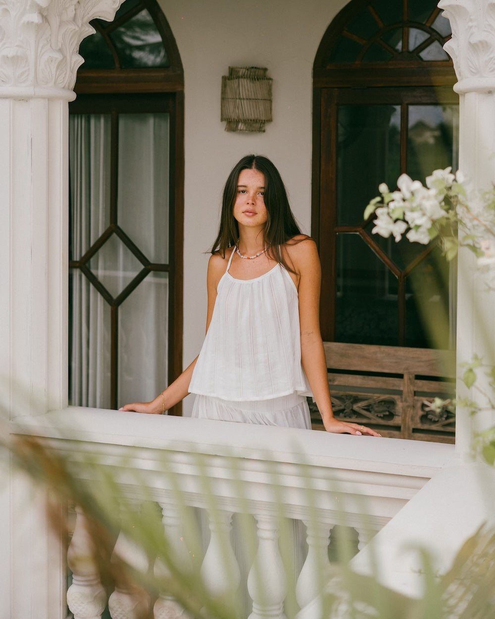 Sole Mare Singlet Top and Maxi Skirt styled on ornate balcony — front-facing full view framed by white arches and timber doorway, gathered halter neckline and floor-length maxi skirt in white handloomed cotton — slow fashion white matching set Australia — Malia The Label La Dolce Vita